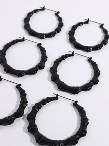 Detailed view of large black bamboo texture hoop earrings with glossy finish and snap closure