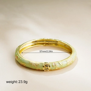 Detail of 57mm enamel bangle showing light green finish and gold flower engraving