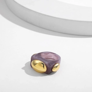 Macro detail of purple marble resin ring with gold oval metallic insets for women