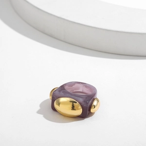 Detailed macro view of purple marble resin ring with inlaid golden metal oval accents