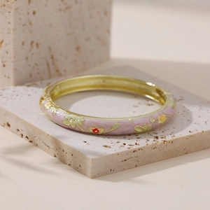 Detailed macro view of pink enamel flower hoop earrings on a natural stone surface