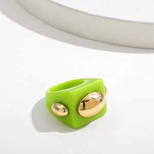 Detail of green resin ring with gold oval metallic inlay for a modern Y2K style look