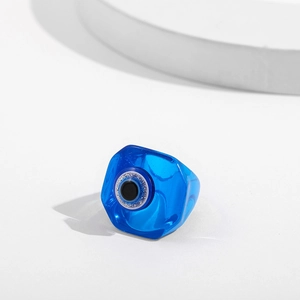 Macro shot of blue resin evil eye ring showing detailed iris and shimmering glitter inlay