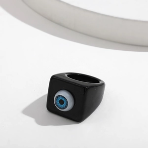 Detailed close-up of a chunky black resin ring featuring a realistic blue eye centerpiece