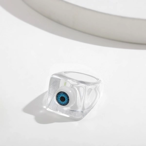 Macro shot of a clear resin square ring featuring a blue evil eye bead detail