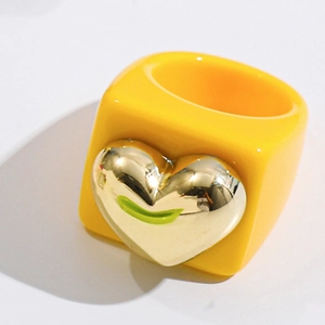 Detail view of yellow square resin ring featuring a bold 3D golden heart accent