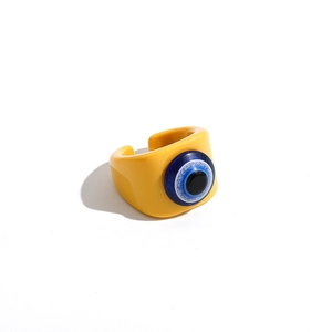 Close-up of yellow resin open ring featuring a blue evil eye centerpiece decoration