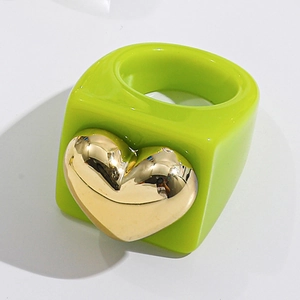 Close-up of green resin ring featuring a large gold heart accent in Y2K aesthetic style