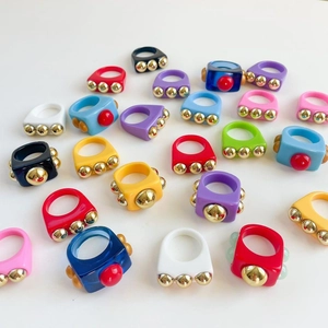 Detailed top view of colorful resin rings with gold metallic stud decorations