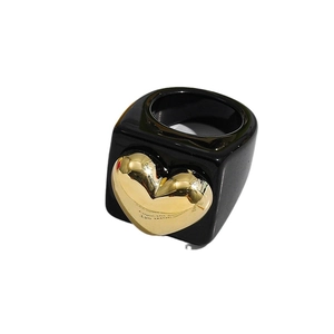 Y2K resin ring featuring a bold black square band and a metallic gold heart centerpiece