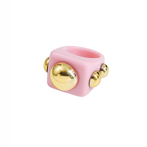Close-up of pink Y2K resin ring with golden bubble studs and metallic accents