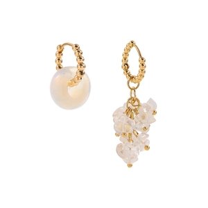 Detail of asymmetric gold earrings with beaded texture and milky white stone charms