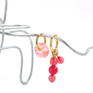 Y2K asymmetric daisy earrings with pink stones and gold hoops on creative stand