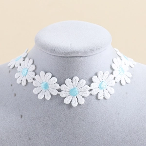Detailopname van witte madeliefje kanten choker ketting op een grijze sieradenbuste