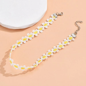 Detail van witte madeliefje kant choker met gele kern en verstelbare sluiting
