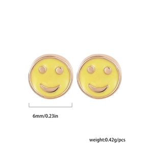Detail view of 6mm yellow enamel smiley face stud earrings with rose gold metallic accents