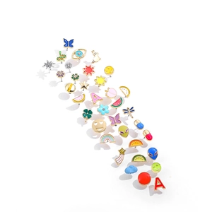 Macro view of assorted Y2K colorful enamel stud earrings with butterflies and smiles