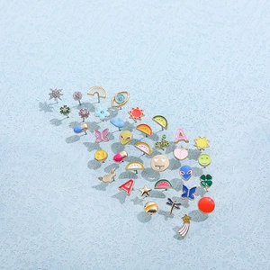 Close-up of colorful enamel stud earrings featuring rainbow, butterfly, and smile patterns