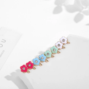 Detailed macro view of seven colorful enamel flower stud earrings with central crystal gems