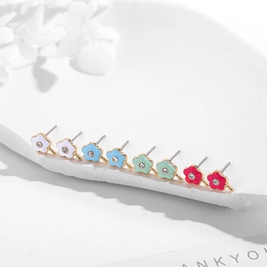 Detail of flower stud earrings with colorful enamel petals and sparkling center crystals
