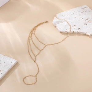 Detail eines mehrlagigen 18K Goldring-Armbands mit feinen Perlen auf Steindekor