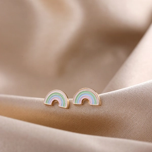 Macro detail of colorful enamel rainbow stud earrings on elegant silk background
