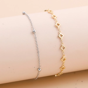 Detailansicht der goldenen Kleekette und des silbernen Perlenarmbandes am Zylinder