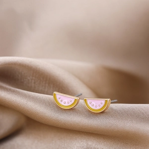 Close-up of watermelon stud earrings with pink and yellow enamel finish on satin