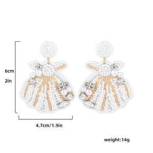 Vue détaillée des boucles d'oreilles coquillage perlé avec dimensions de 6 cm de long et 4,7 cm