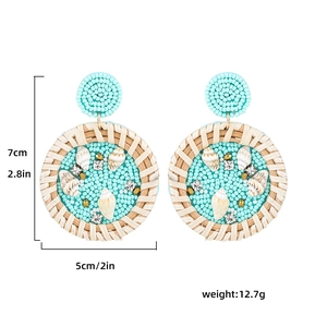 Détail de boucles d'oreilles en perles colorées avec étoile de mer et cadre en rotin