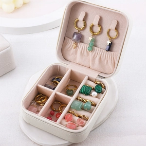Detailed view of asymmetric geometric earrings stored in a compact jewelry box organizer