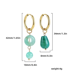 Detail view of asymmetric gold geometric earrings with green stone and size measurements