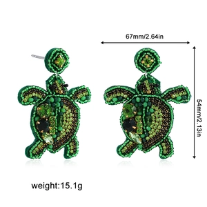 Vue détaillée de boucles d'oreilles tortue en perles vertes avec pierres scintillantes