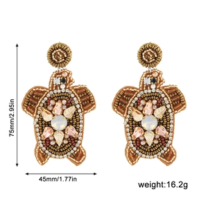 Détail de boucles d'oreilles tortue en perles faites main avec cristaux et taille 75mm