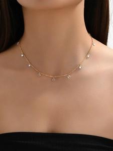 Detalle del collar de mariposa en oro de 14K con colgantes de cristal en el cuello de modelo
