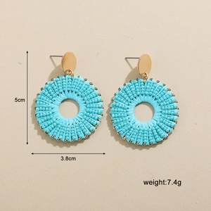 Détail de boucles d'oreilles en perles bleu clair avec clous dorés et dimensions
