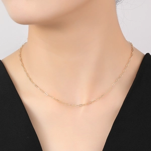 Primer plano de collar de mariposa en oro de 14K sobre modelo con cadena de clips