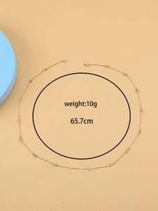 Detalle de cadena corporal dorada de 65,7 cm con colgantes triangulares y peso de 10g
