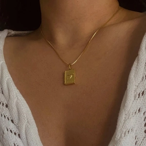 Vintage golden heart-embossed book locket necklace on a minimalist link chain