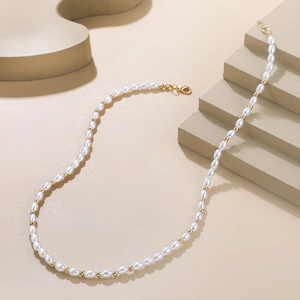 Détail du collier de perles de riz avec perles dorées et fermoir mousqueton chic
