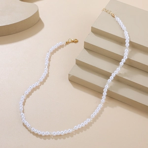 Détail du collier de perles minimaliste avec fermoir mousqueton doré et chaîne réglable