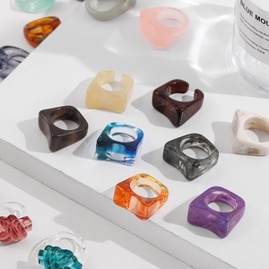 Buntes Harzring-Set mit Marmor- und Bernsteinmustern auf einem weißen minimalistischen Display