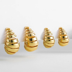 Vista detallada de pendientes de gota en espiral huecos bañados en oro de 18 quilates