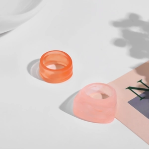 Detailansicht bunter Harzringe in Orange und Rosa mit modernem geometrischem Y2K-Design