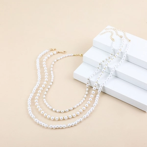 Ensemble de trois colliers en perles blanches avec élégants fermoirs dorés en métal