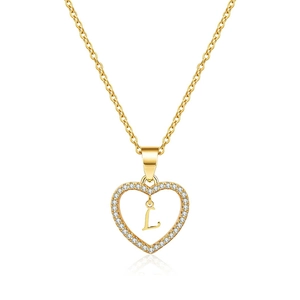 Detailed shot of a gold heart pendant with zircon pavé and a central letter L charm