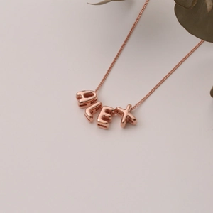 Macro shot of custom rose gold name necklace featuring ALEX 3D letter pendant