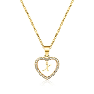 Macro detail of gold heart pendant with cubic zirconia and letter K on cable chain