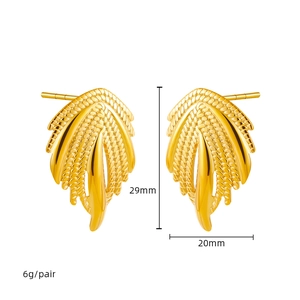 Vue détaillée de boucles d'oreilles ailes en or 18K avec textures de plumes en métal