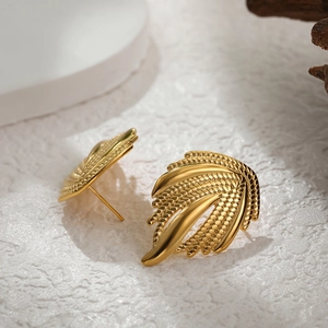 Vue détaillée de boucles d'oreilles ailes dorées avec texture de nervures de feuilles